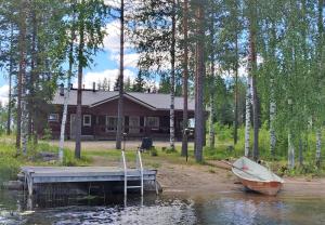 um barco está ancorado numa doca em frente a uma casa em Lomavouti Cottages em Savonranta