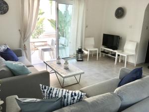 un soggiorno con divano, tavolo e TV di Palma Villa 14 a Protaras