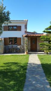 a house with a pathway in front of it at BAREFOOT COTTAGE in Skiathos