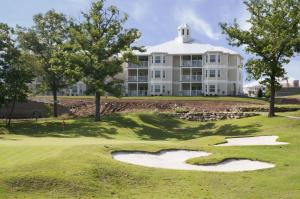 - un parcours de golf avec un grand bâtiment blanc dans l'établissement Holiday Inn Club Vacations Holiday Hills Resort at Branson an IHG Hotel, à Branson
