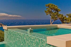 a swimming pool with a view of the ocean at Lux View Suites in Kyra Panagia