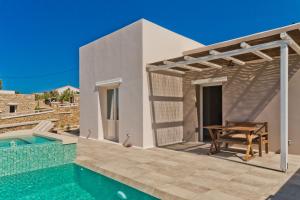 a villa with a swimming pool and a table at Lux View Suites in Kyra Panagia