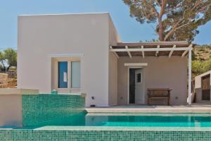 a house with a swimming pool in front of it at Lux View Suites in Kyra Panagia
