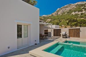 a villa with a swimming pool and a house at Lux View Suites in Kyra Panagia