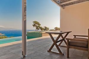 a table and chair on a patio with a view of the ocean at Lux View Suites in Kyra Panagia
