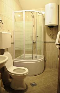 a bathroom with a shower and a toilet and a sink at Hotel Evropa in Podgorica