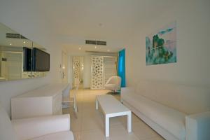 a white living room with a couch and a table at Costa Luvi Hotel Bodrum - All Inclusive in Gümbet