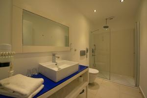 a bathroom with a sink and a shower and a toilet at Costa Luvi Hotel Bodrum - All Inclusive in Gümbet