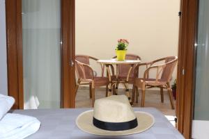 um chapéu sentado em cima de uma mesa com cadeiras em Dimitra Boutique Hotel em Poros