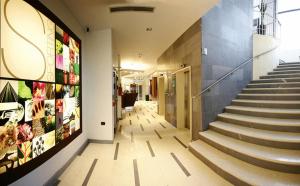 a hallway of a building with stairs and posters on the wall at Hotel Sporting Cologno in Cologno Monzese