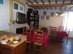 un soggiorno con tavolo e TV di Chambres et Tables d'hôtes à l'Auberge Touristique a Meuvaines