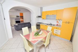 a kitchen and dining room with a table and yellow cabinets at SOLEMAREPONZA Casa la Randa in Ponza