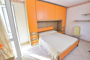 a bedroom with orange cabinets and a bed and a chair at SOLEMAREPONZA Casa la Randa in Ponza