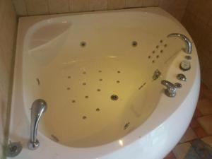 a white bath tub with a metal fixtures in a bathroom at Ranna Hostel in Pärnu