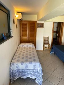 a small bedroom with a bed and a chair at Casa Salina in Santa Marina Salina