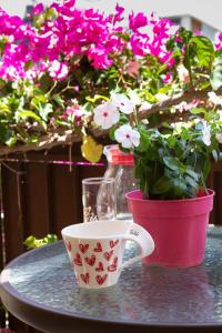 Stella Rooms في تولو: كوب من القهوة و قدر من الزهور على طاولة