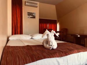 dwa wypchane zwierzęta siedzące na łóżku w pokoju hotelowym w obiekcie Family Hotel Deja Vu w Rawdzie