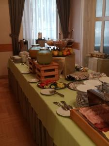 un lungo tavolo con piatti di cibo sopra di Hotel Blaha Lujza a Balatonfüred