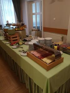 a long table with plates and food on it at Hotel Blaha Lujza in Balatonfüred