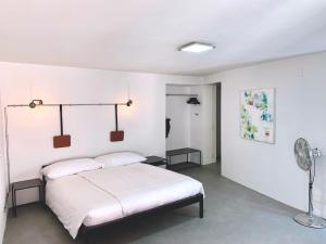 een witte slaapkamer met een bed en een ventilator bij Great2Stay City Center Apartments in Locarno