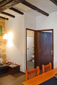 sala de estar con mesa de comedor y baño en Casa Manolita, en Calaceite