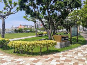 un parque con un cartel en un parque con árboles en NahaCentaral_10Beds7roomsHouse_190sqm_FreeParking, en Naha