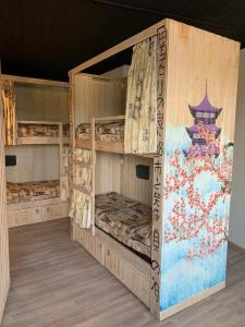 two bunk beds in a room with a painting on the wall at Хостел Жить просто 2 in Pyatigorsk