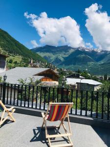 - deux chaises sur un balcon avec vue sur les montagnes dans l'établissement Hotel Elite House, à Mestia