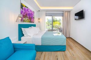 a bedroom with a bed and a blue couch at Maria Elena Suites in Limenas