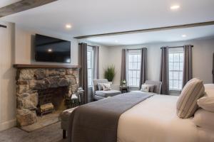 a bedroom with a large bed and a fireplace at Mountain Meadows Lodge in Killington