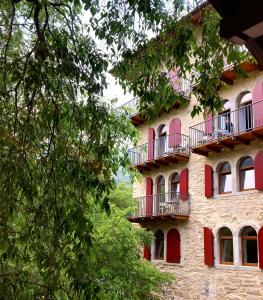 un edificio con puertas rojas y balcones. en La Berlera - Riva del Garda, en Riva del Garda