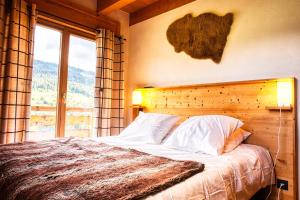 Schlafzimmer mit einem Bett und einem großen Fenster in der Unterkunft Chalet le Feston in Praz-sur-Arly