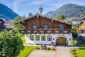 a house in the mountains with a balcony at Frühstückspension Klinglhub in Flachau