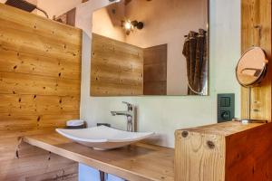 un bagno con lavandino bianco su un bancone in legno di Chalet le Feston a Praz-sur-Arly