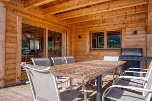 阿爾利河畔普拉茲的住宿－Chalet le Feston，木制甲板配有木桌和椅子