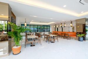 美索Monte Maesot hotel的有桌椅和沙发的餐厅