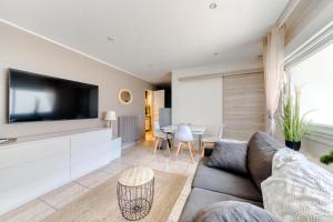 a living room with a couch and a flat screen tv at Cosy apartment + secured PARKING in Cannes