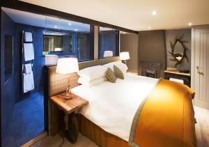 a large bedroom with a large bed with a table at The Dalesman Country Inn in Sedbergh