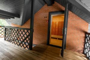 a brick building with a door on a deck at Palanga Camping Hostel in Palanga +5 photos
