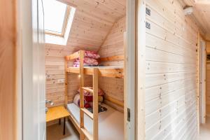 a tiny house with wooden walls and a ladder at Palanga Camping Hostel in Palanga