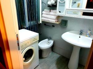 un bagno con lavatrice e lavandino di Lorena Loft a Locri