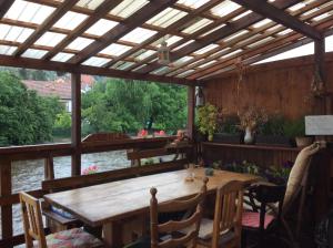 uma pérgola de madeira com uma mesa e cadeiras de madeira em Hostelskippy em Cesky Krumlov