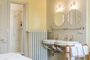 a bathroom with two sinks and a shower with mirrors at Hotel Regina in Mürren