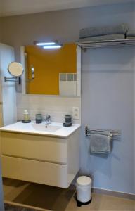 a bathroom with a sink and a yellow mirror at Les terrasses de Malmedy Studio 333 Yellow Grey in Malmedy