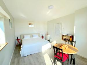 1 dormitorio con cama blanca y mesa en Who's Anton for you or two, Monnickendam near Amsterdam, en Monnickendam