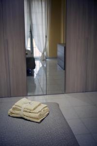 - une pile de serviettes assises sur un lit dans la chambre dans l'établissement STANZA EUCALIPTO, à Caserte