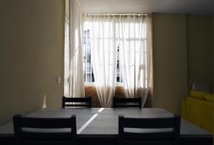 a dining room table with chairs and a large window at STANZA EUCALIPTO in Caserta