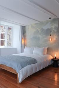 - une chambre avec un grand lit orné d'une peinture murale dans l'établissement Artist Flat Saint Flour, à Saint-Flour