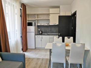 a kitchen and dining room with a table and chairs at Family Apartment for Short-Term Vacation in Primorsko