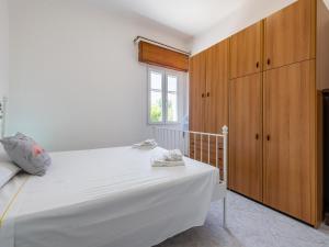 a bedroom with a white bed and wooden cabinets at Casa Nunzia in SantʼAndrea